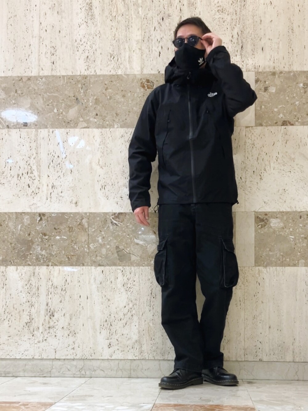 ブラック系のマウンテンパーカー、ブラック系のカーゴパンツ、ブラック系のその他シューズを着用したメンズの春コーディネートの2枚目の写真