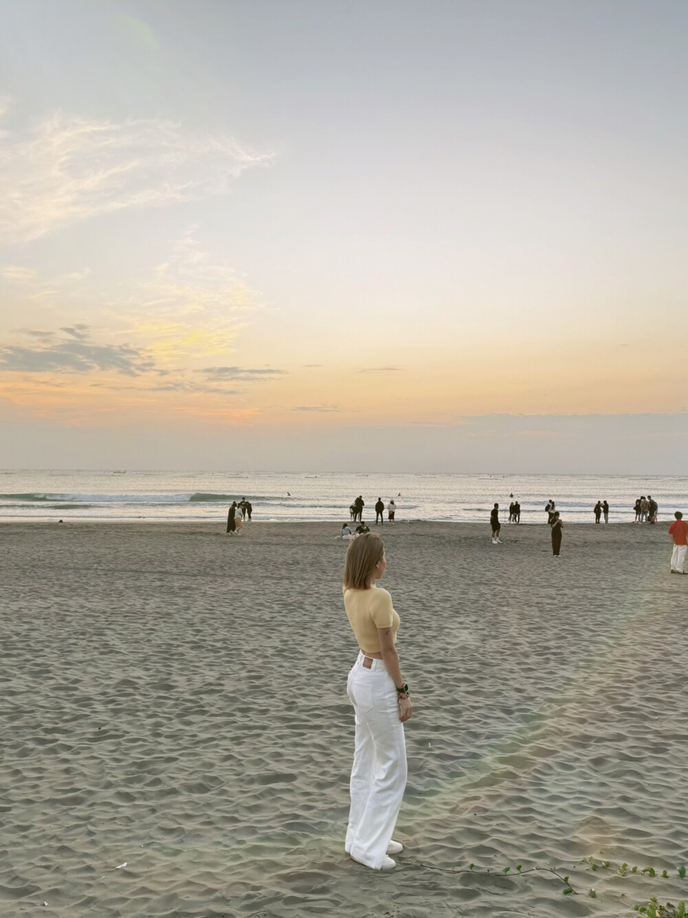 イエロー系のニット/セーター、ホワイト系のデニムパンツを着用したレディースの冬コーディネートの3枚目の写真