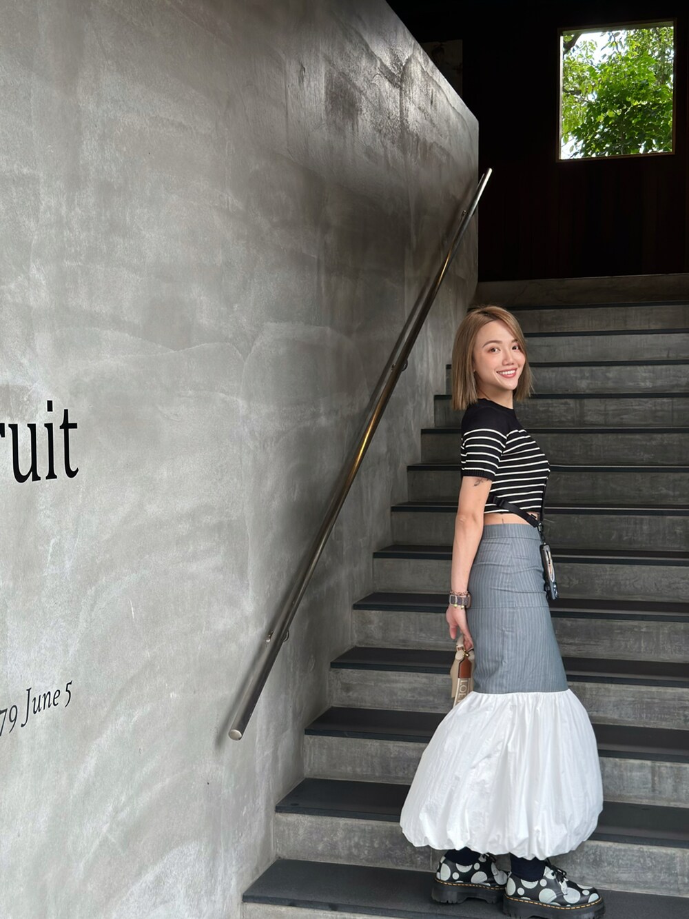 ブルー系のスカート、ベージュ系のバッグ、ブラック系のローファーを着用したレディースの冬コーディネートの2枚目の写真