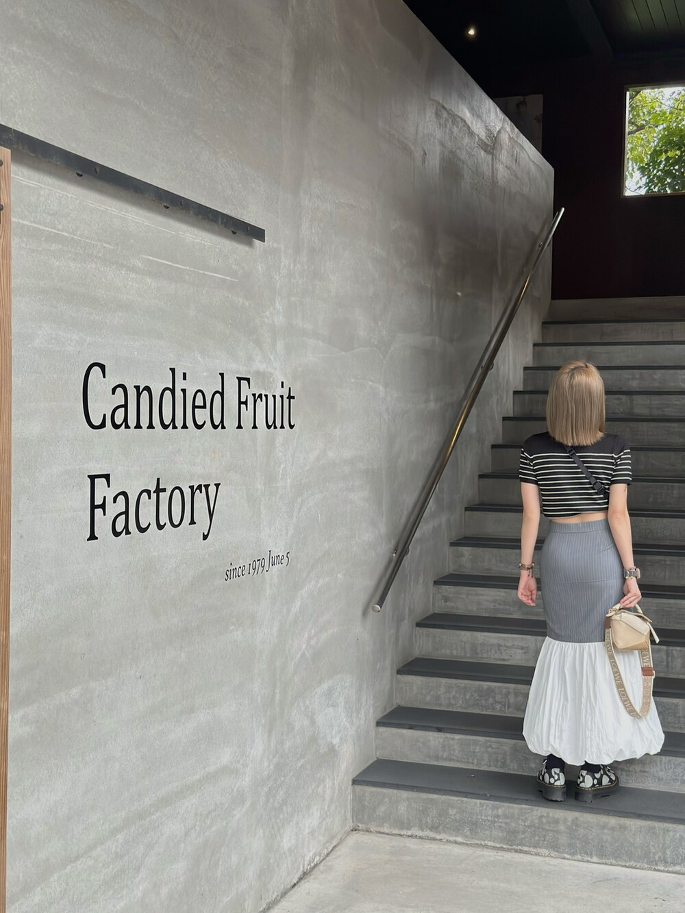 ブルー系のスカート、ベージュ系のバッグ、ブラック系のローファーを着用したレディースの冬コーディネートの4枚目の写真