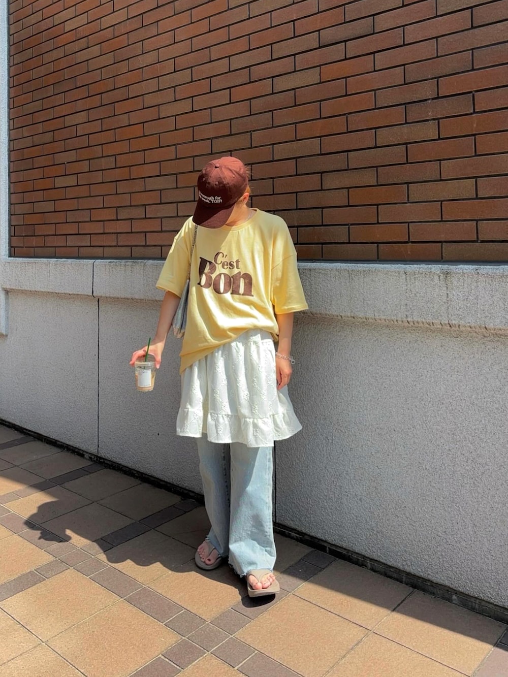 ホワイト系のワンピース、イエロー系のTシャツ/カットソー、ブルー系のデニムパンツを着用したレディースの夏コーディネートの3枚目の写真