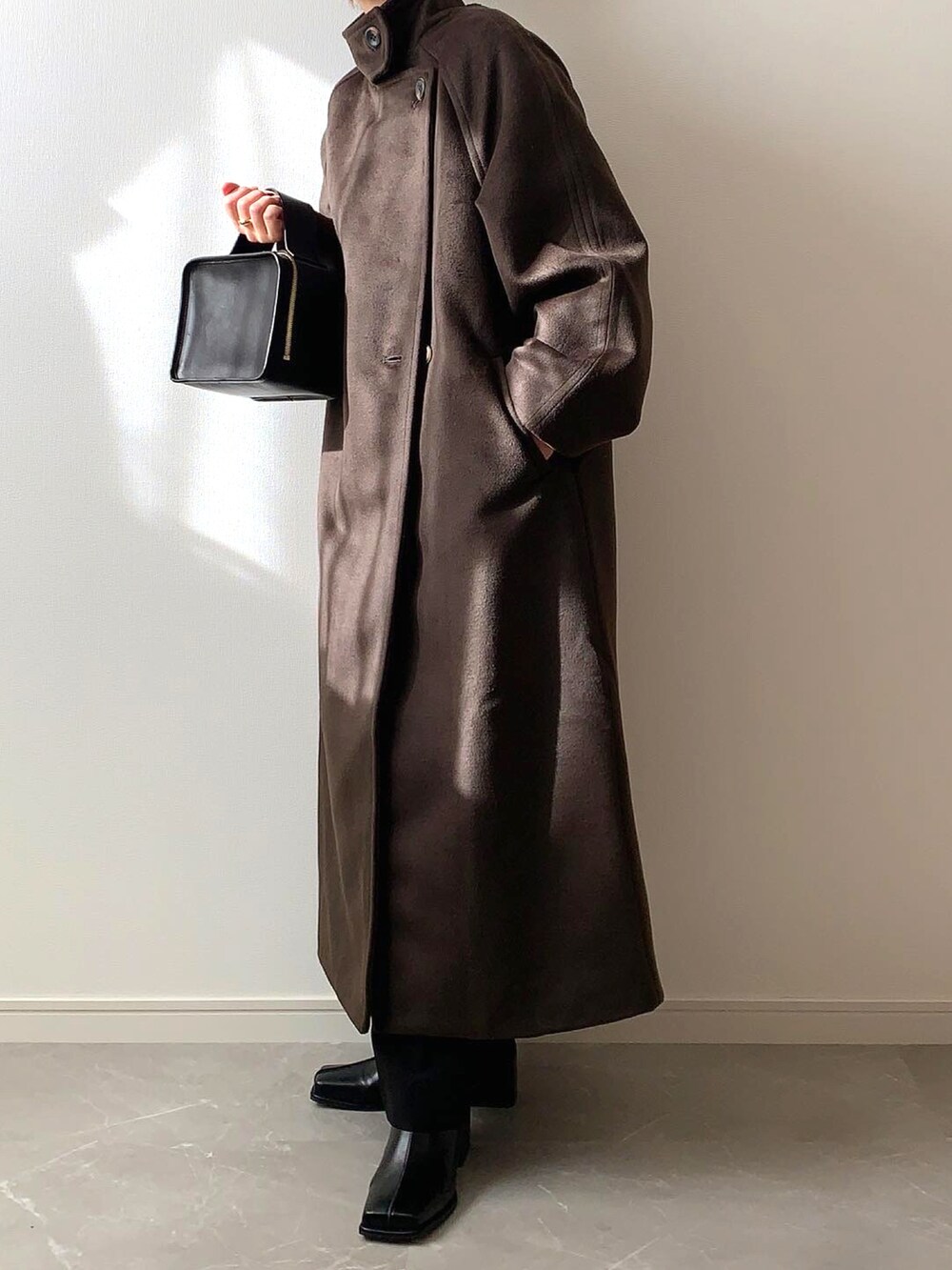 ブラウン系のその他アウター、ブラック系のブーツを着用したレディースの冬コーディネートの2枚目の写真