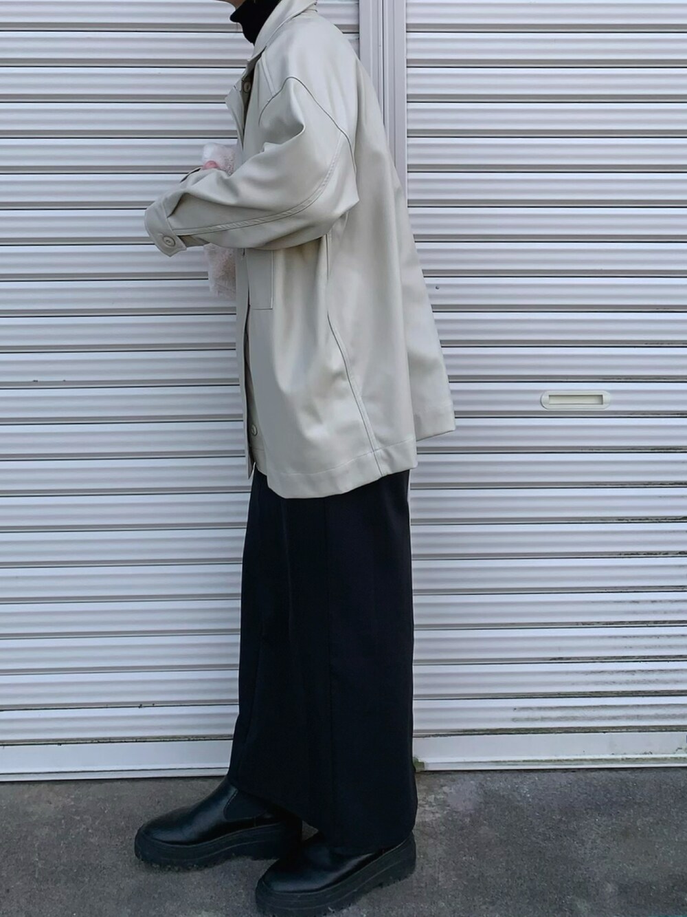 ホワイト系のバッグ、ブラック系のスカートを着用したレディースの冬コーディネートの2枚目の写真