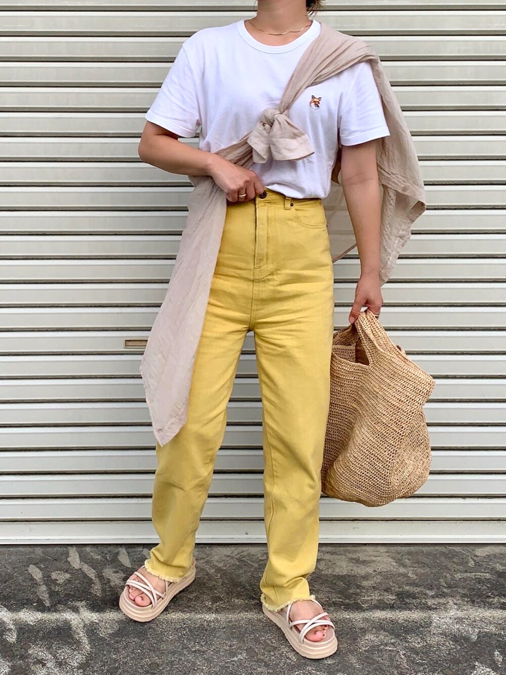 ホワイト系のTシャツ/カットソー、イエロー系のデニムパンツ、ベージュ系のトートバッグを着用したレディースの夏コーディネートの2枚目の写真