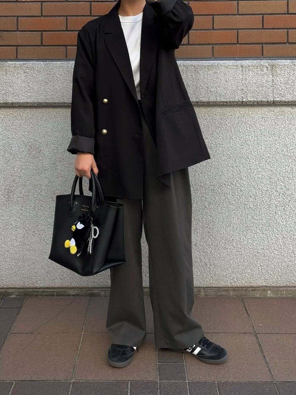 ブラック系のテーラードジャケットを着用したレディースの春コーディネートの2枚目の写真