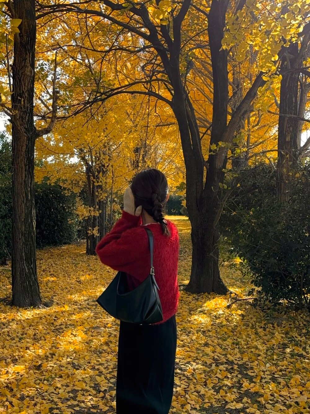 レッド系のカーディガン/ボレロを着用したレディースの冬コーディネートの2枚目の写真