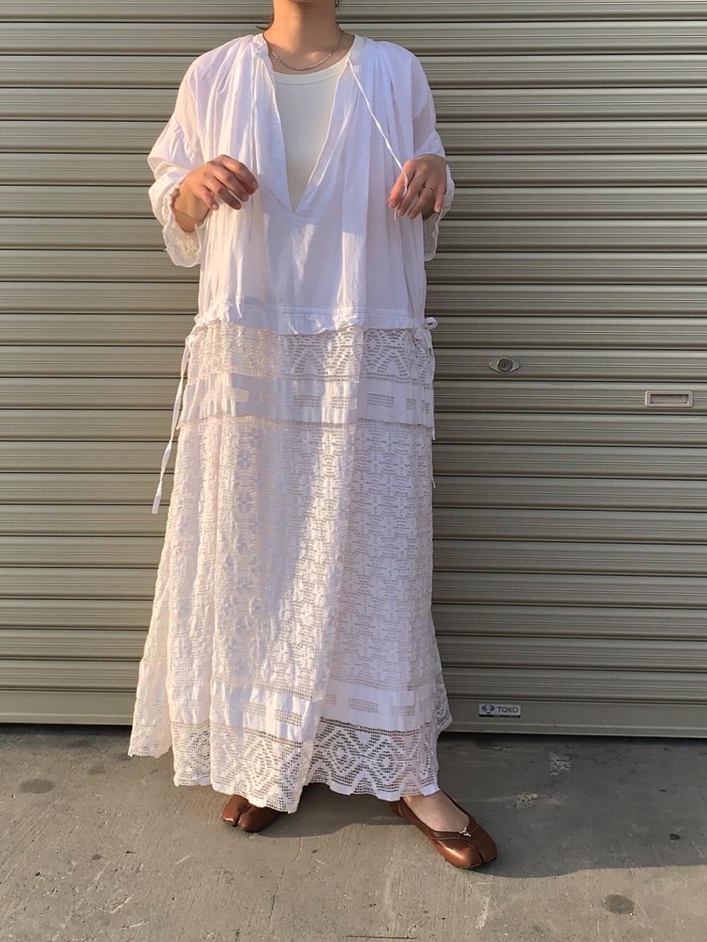 ホワイト系のワンピース、ブラウン系のシューズを着用したレディースの春コーディネートの2枚目の写真