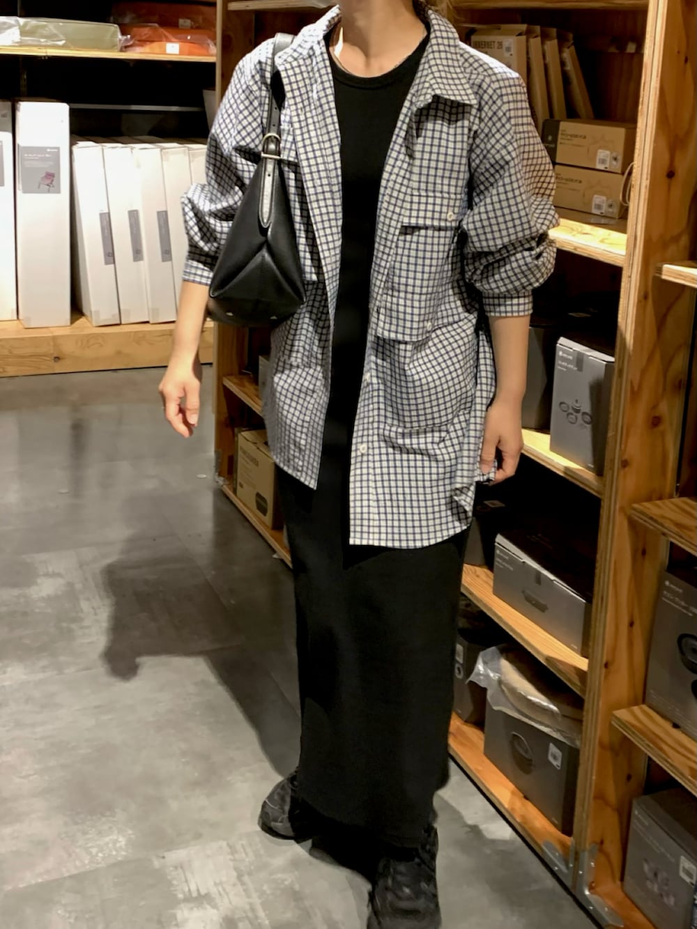 ブラック系のワンピース、ブルー系のシャツ/ブラウスを着用したレディースの春コーディネートの2枚目の写真