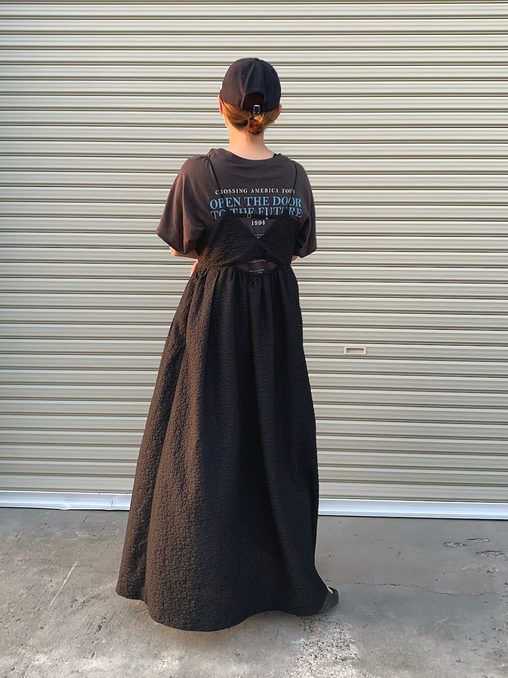 グレー系のTシャツ/カットソー、ブラック系のワンピース、ブラック系のサンダルを着用したレディースの夏コーディネートの2枚目の写真