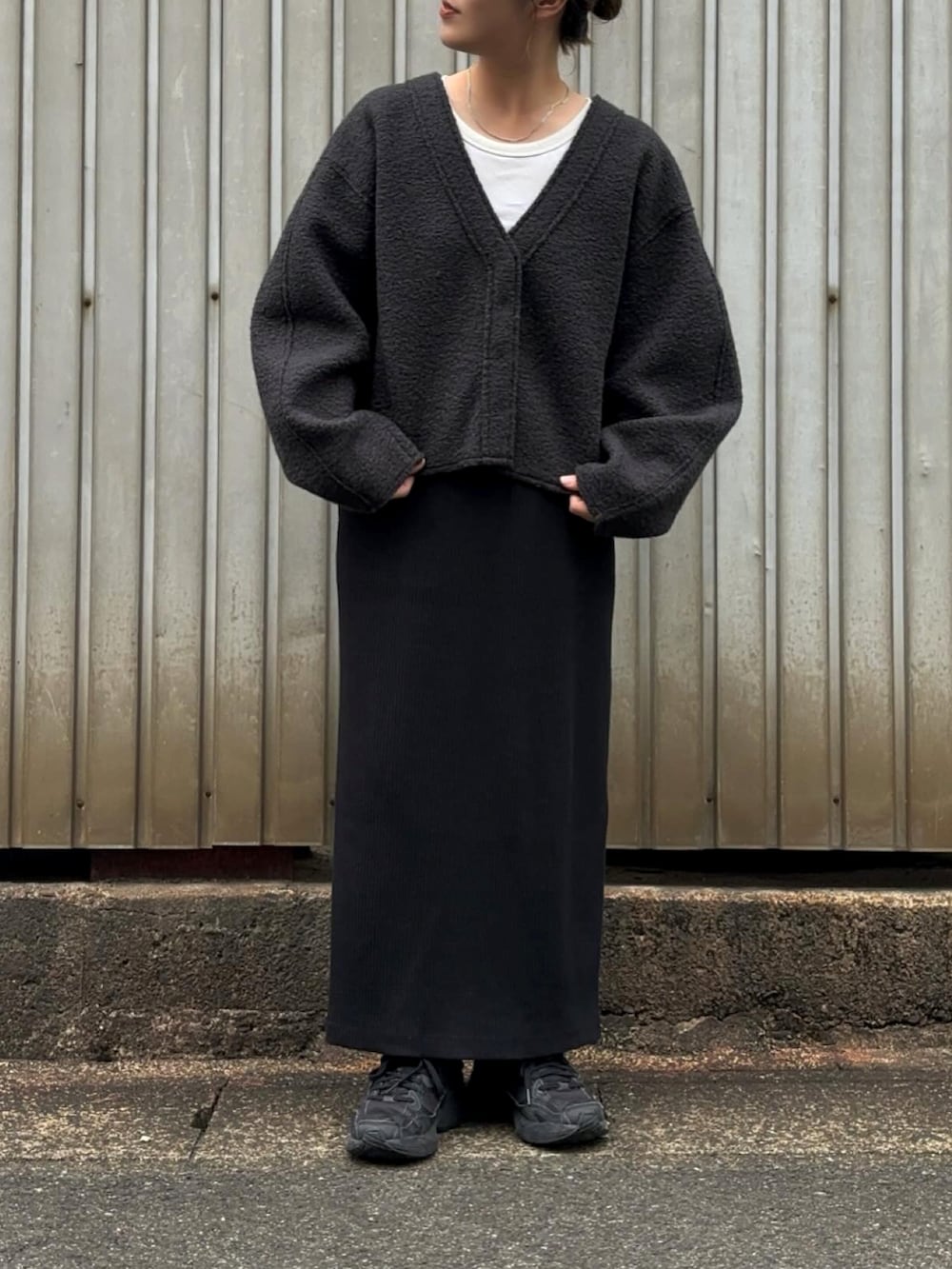 グレー系のカーディガン/ボレロ、ブラック系のスカート、ブラック系のスニーカーを着用したレディースの秋コーディネートの2枚目の写真