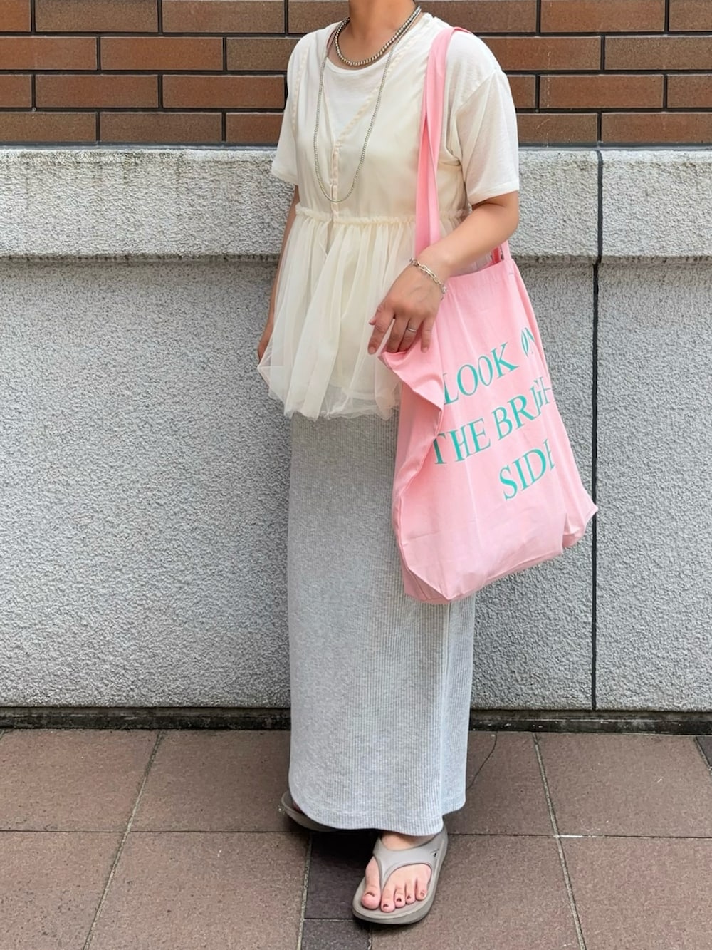 ピンク系のトートバッグを着用したレディースの夏コーディネートの2枚目の写真
