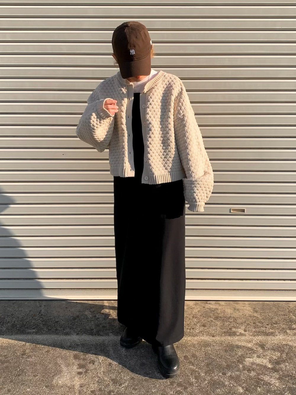 ホワイト系のカーディガン/ボレロ、ブラック系のワンピースを着用したレディースの冬コーディネートの2枚目の写真