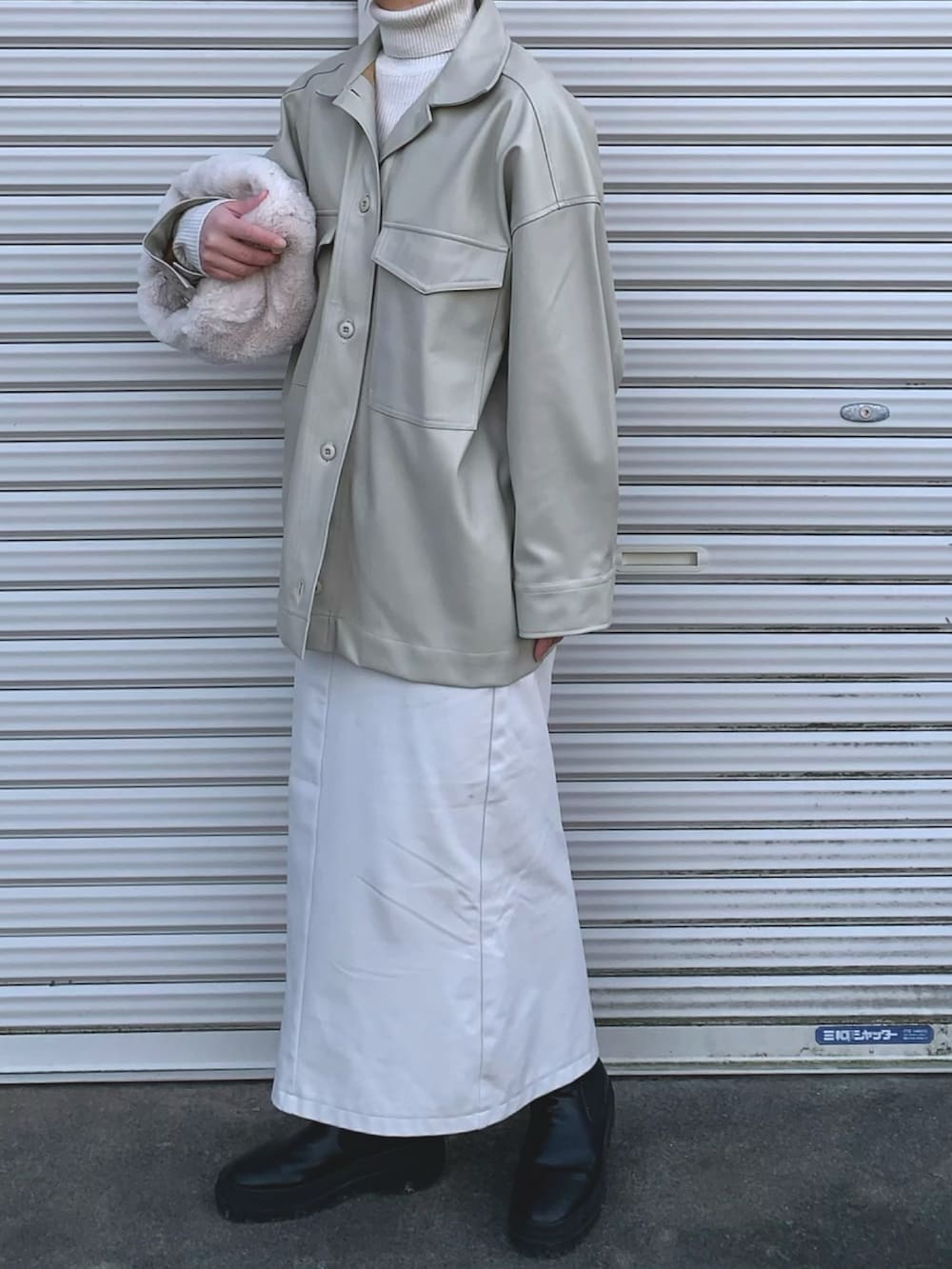 ホワイト系のスカート、ホワイト系のバッグを着用したレディースの冬コーディネートの2枚目の写真