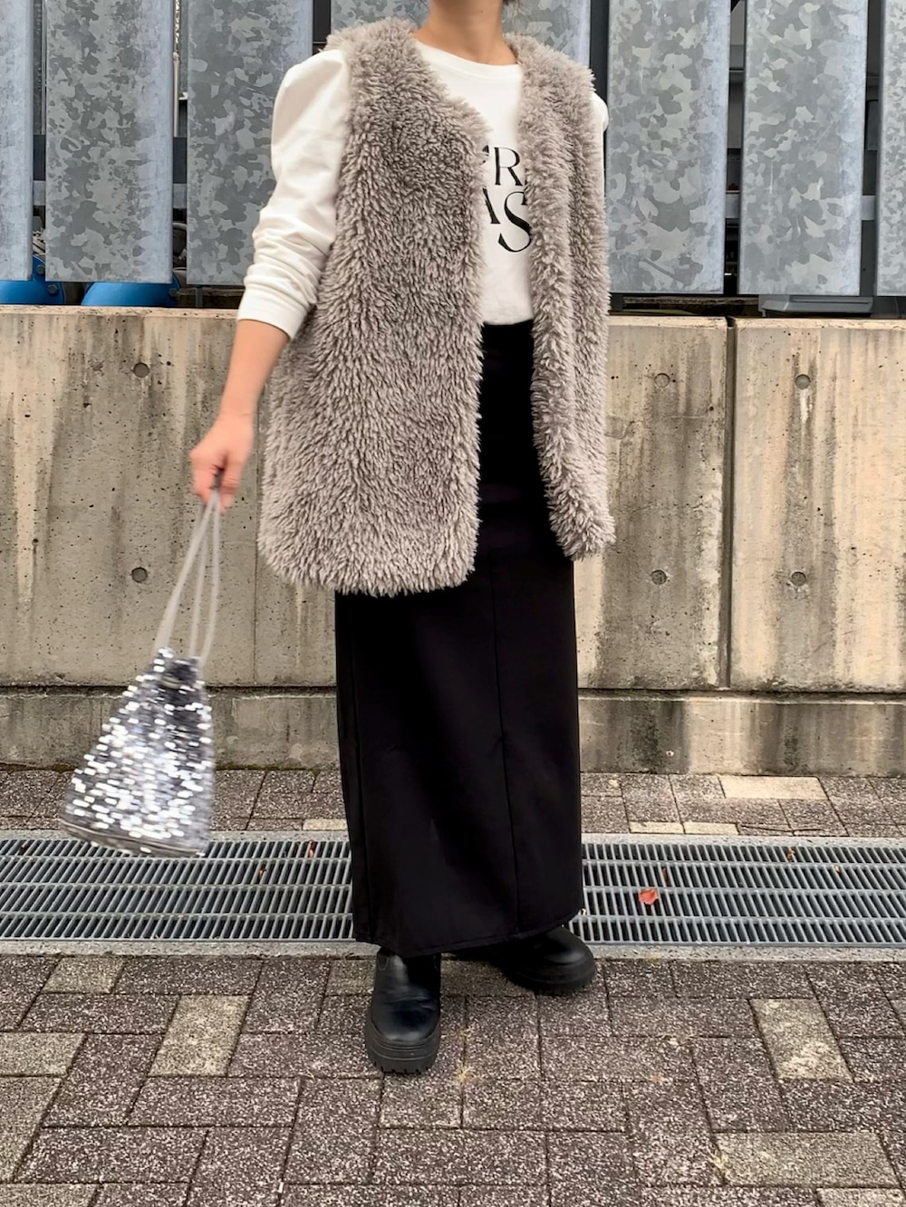 グレー系のノーカラージャケット、ホワイト系のTシャツ/カットソー、シルバー系のショルダーバッグを着用したレディースの秋コーディネートの2枚目の写真