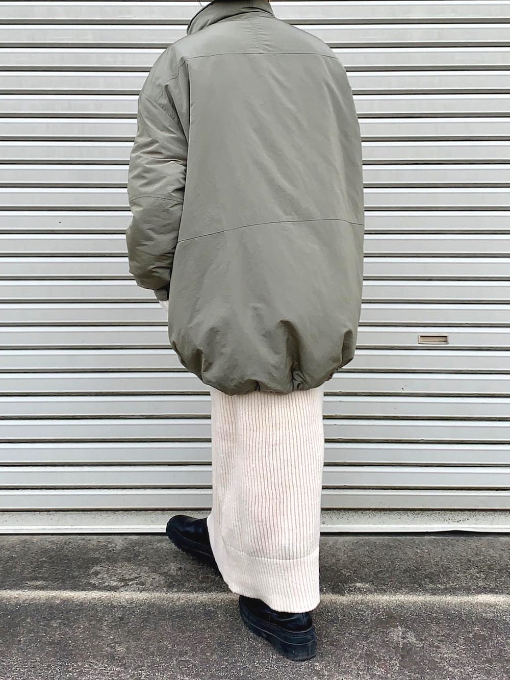 グリーン系のテーラードジャケット、ホワイト系のワンピースを着用したレディースの冬コーディネートの3枚目の写真