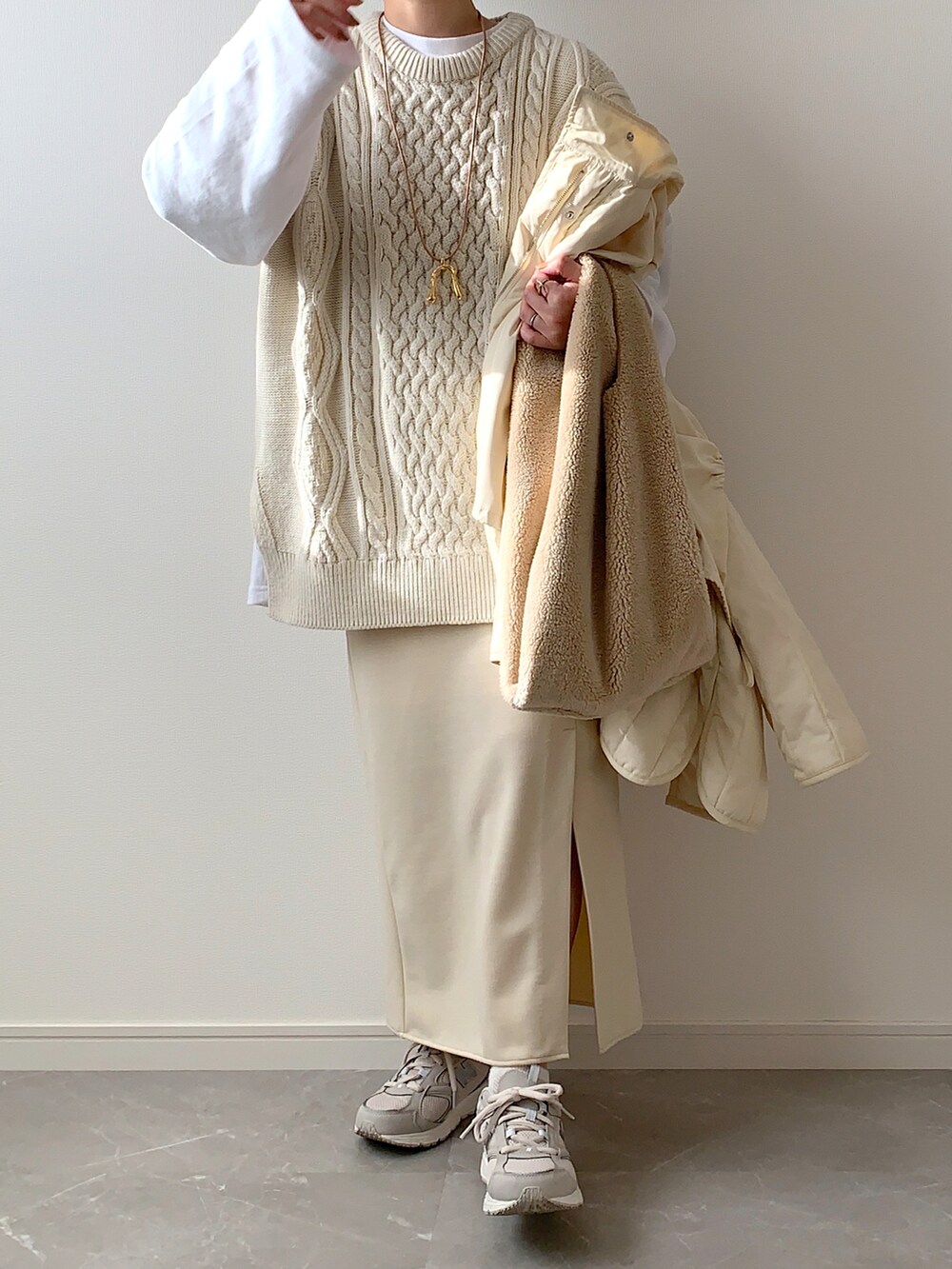 ホワイト系のダウンジャケット/コート、ホワイト系のベスト、ホワイト系のスカートを着用したレディースの冬コーディネートの3枚目の写真