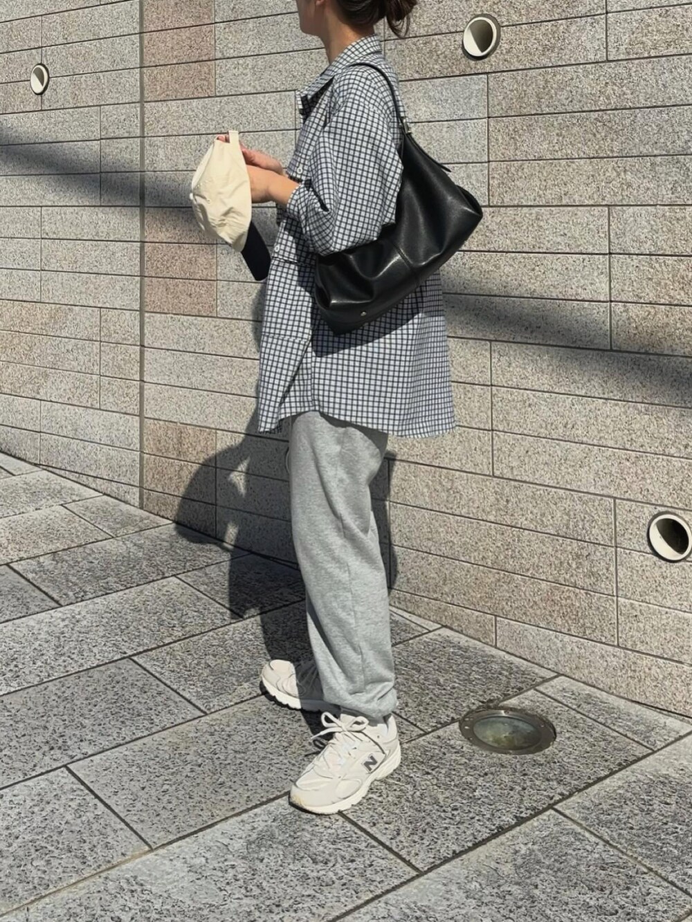 グレー系のスウェットパンツ、ブルー系のシャツ/ブラウス、ホワイト系のキャップを着用したレディースの秋コーディネートの3枚目の写真