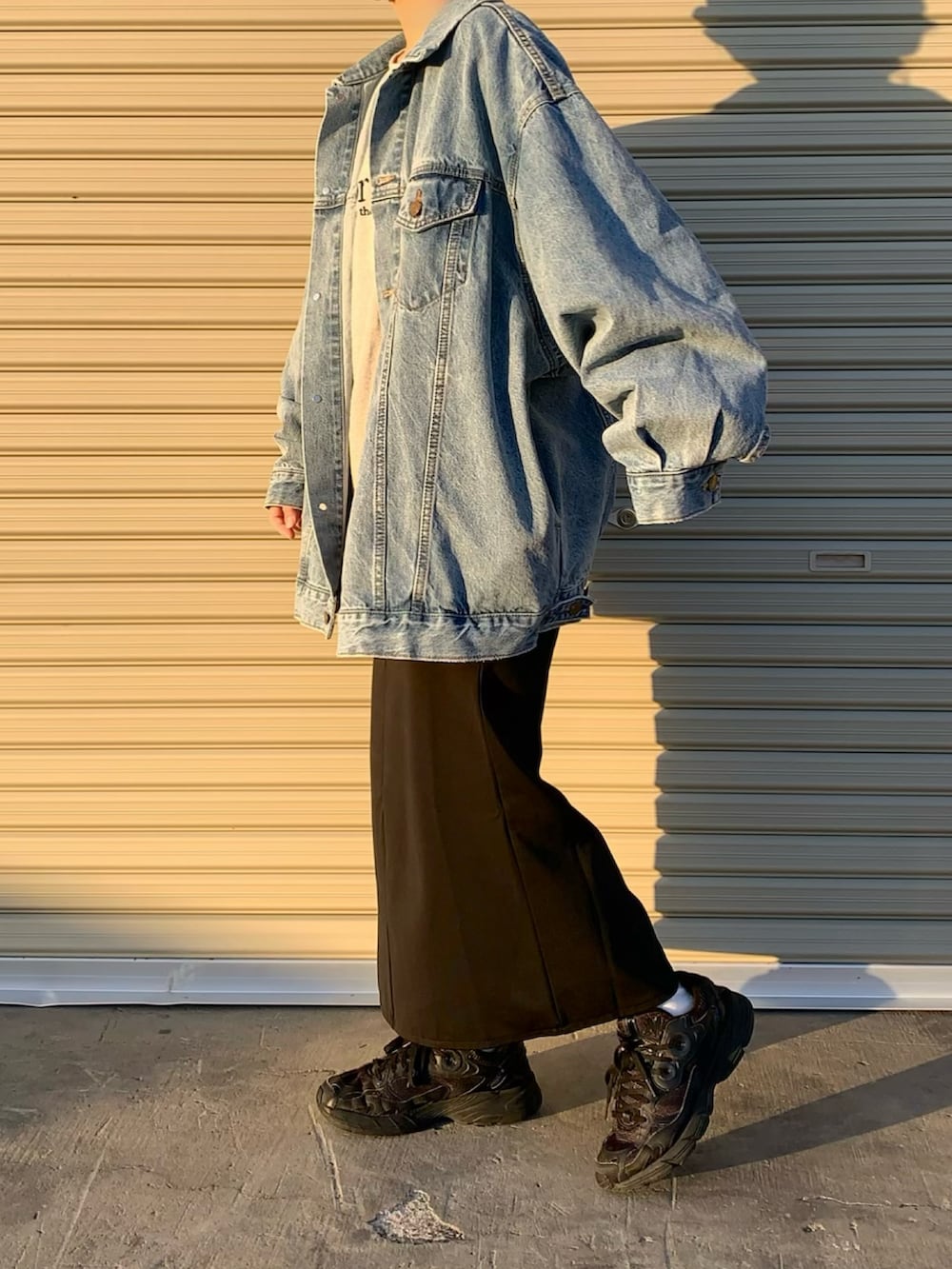 ブルー系のデニムジャケット、グレー系のスウェット、ブラック系のスニーカーを着用したレディースの冬コーディネートの2枚目の写真