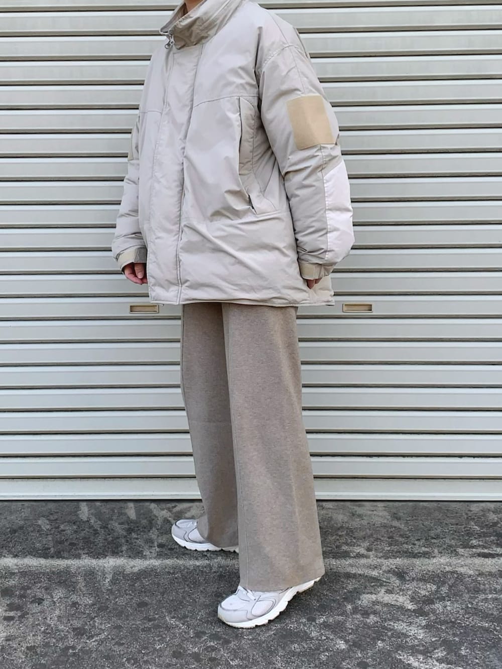 ベージュ系のその他パンツ、グレー系のダウンジャケット/コート、ホワイト系のスニーカーを着用したレディースの冬コーディネートの3枚目の写真