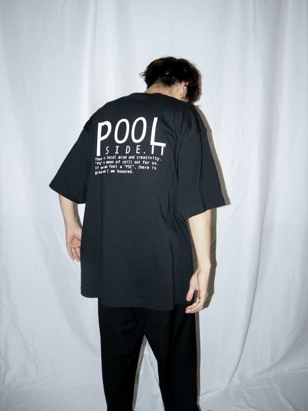 ブラック系のスラックス、ブラック系のサンダル、ブラック系のTシャツ/カットソーを着用したメンズの夏コーディネートの2枚目の写真
