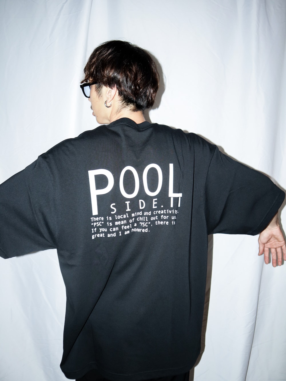 ブラック系のスラックス、ブラック系のサンダル、ブラック系のTシャツ/カットソーを着用したメンズの夏コーディネートの3枚目の写真