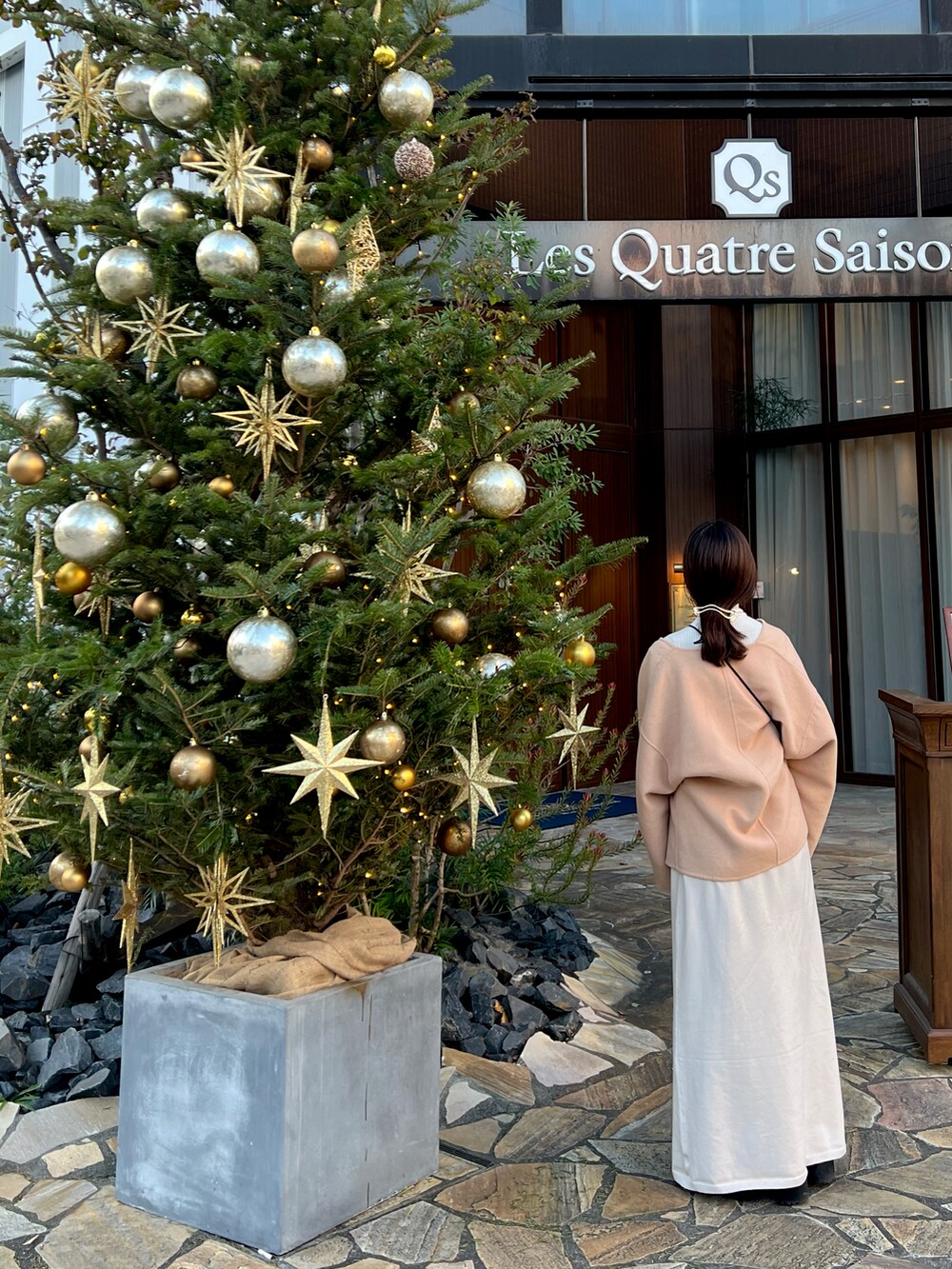 その他のノーカラージャケット、ブラック系のショルダーバッグ、ホワイト系のワンピースを着用したレディースの冬コーディネートの2枚目の写真