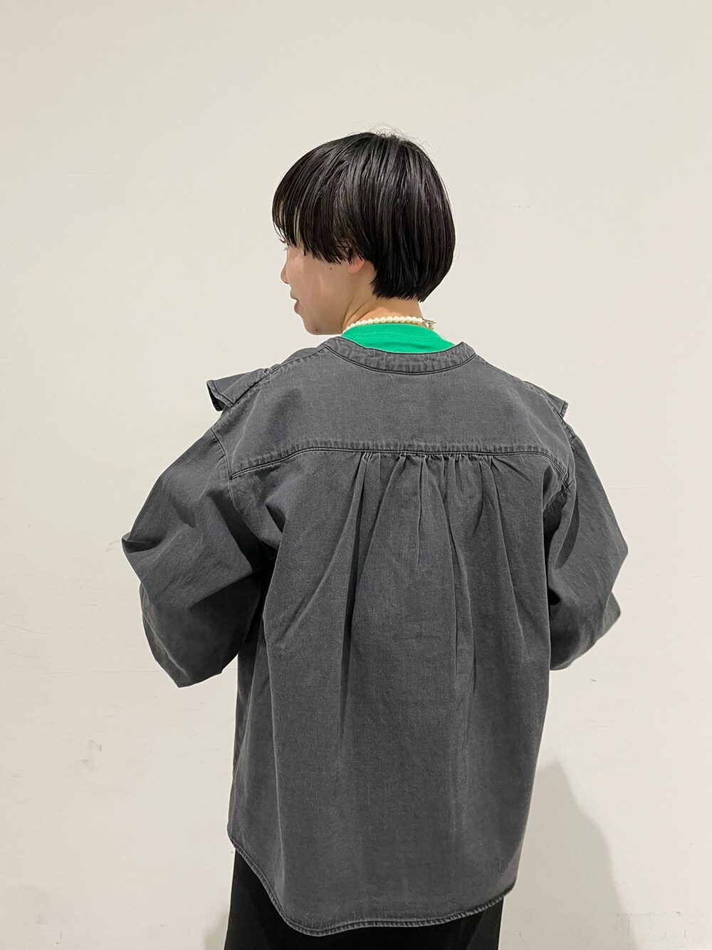 グリーン系のTシャツ/カットソー、ブラック系のシャツ/ブラウス、ブラック系のスカートを着用したレディースの冬コーディネートの5枚目の写真