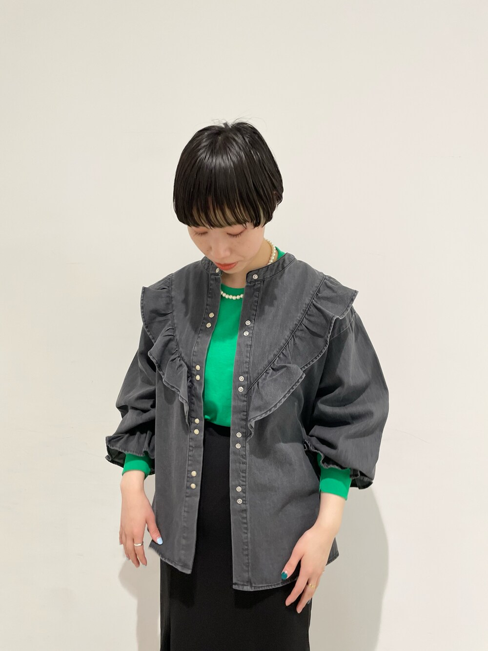 グリーン系のTシャツ/カットソー、ブラック系のシャツ/ブラウス、ブラック系のスカートを着用したレディースの冬コーディネートの4枚目の写真