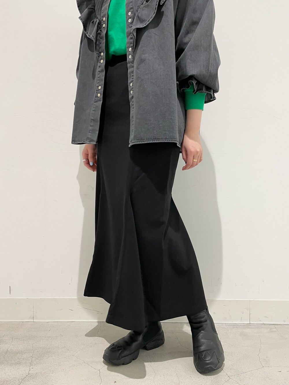 グリーン系のTシャツ/カットソー、ブラック系のシャツ/ブラウス、ブラック系のスカートを着用したレディースの冬コーディネートの3枚目の写真