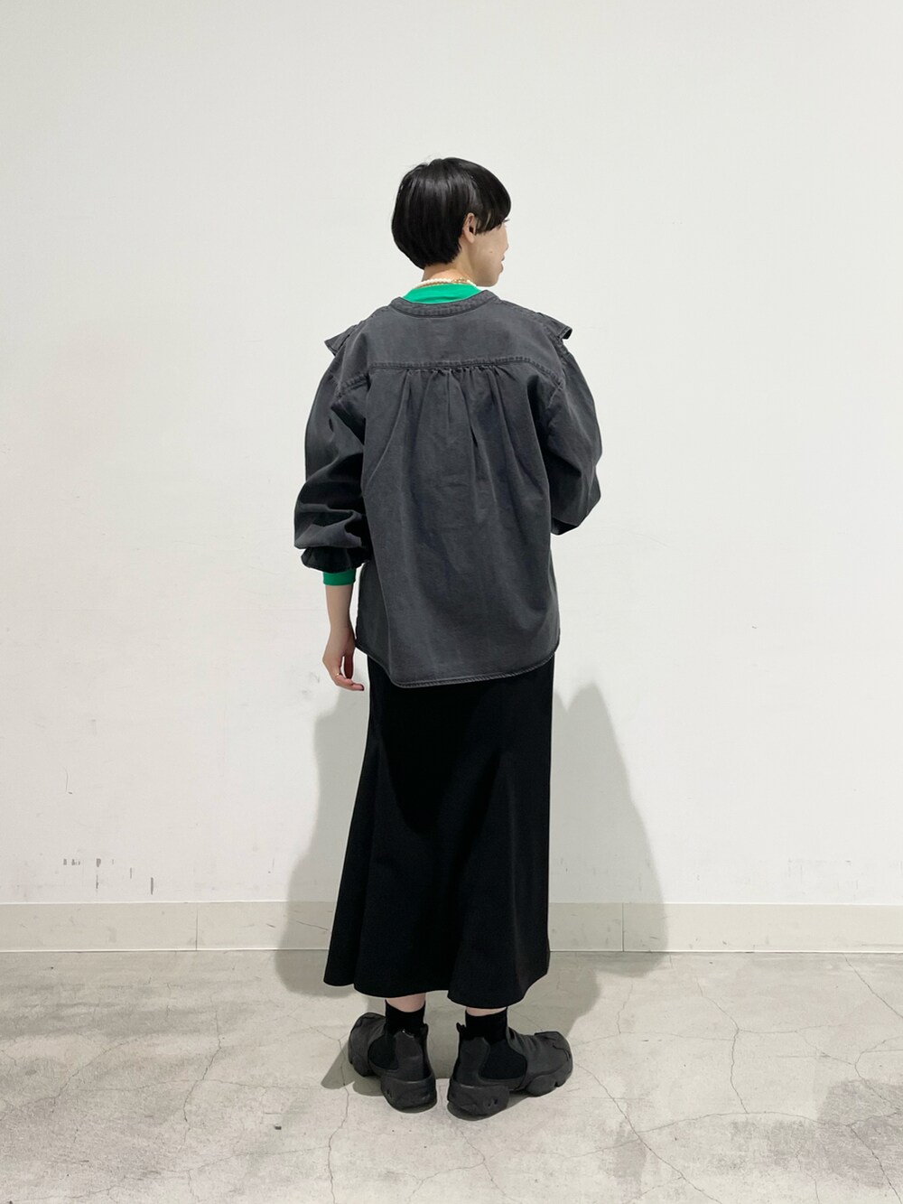 グリーン系のTシャツ/カットソー、ブラック系のシャツ/ブラウス、ブラック系のスカートを着用したレディースの冬コーディネートの2枚目の写真