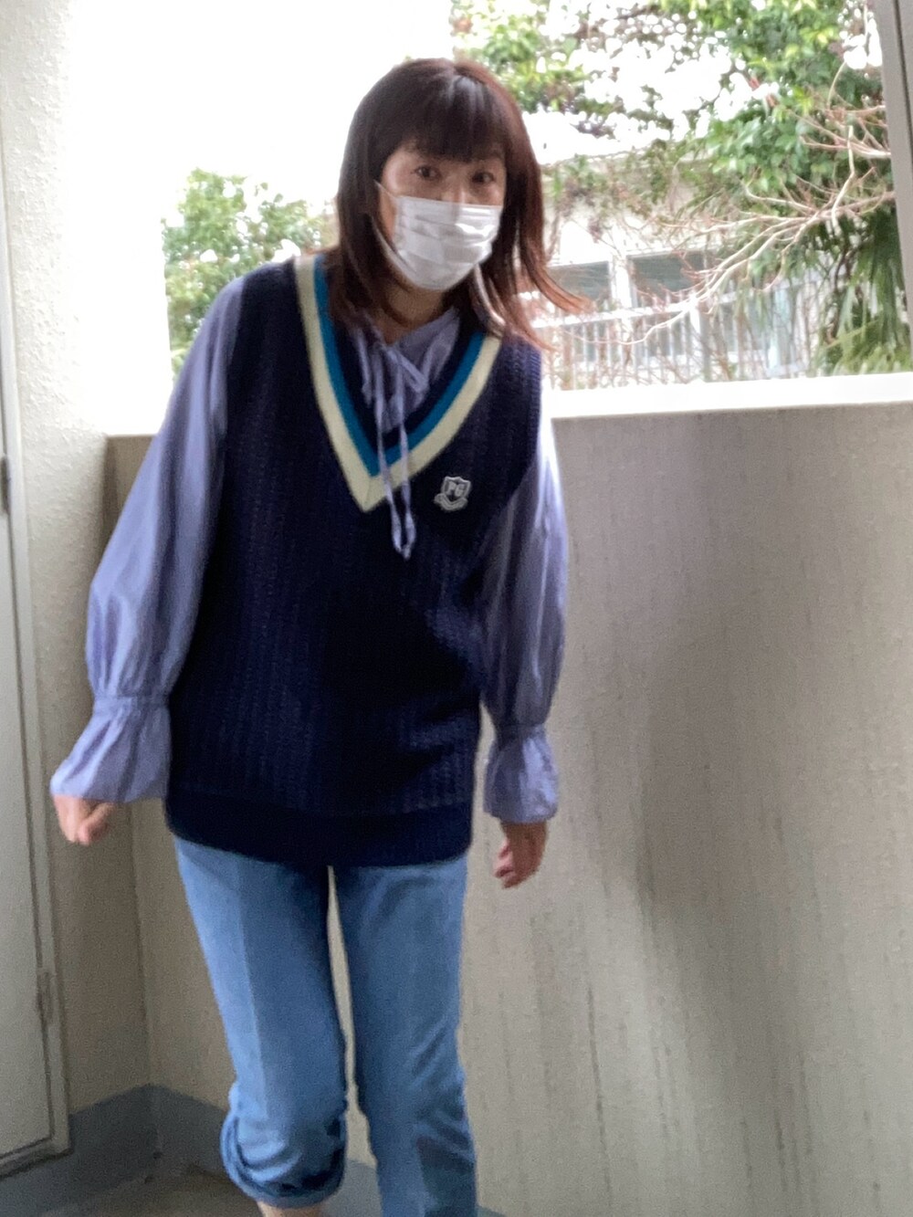 ブルー系のベスト、ブルー系のシャツ/ブラウス、ブルー系のチノパンツを着用したレディースの冬コーディネートの2枚目の写真