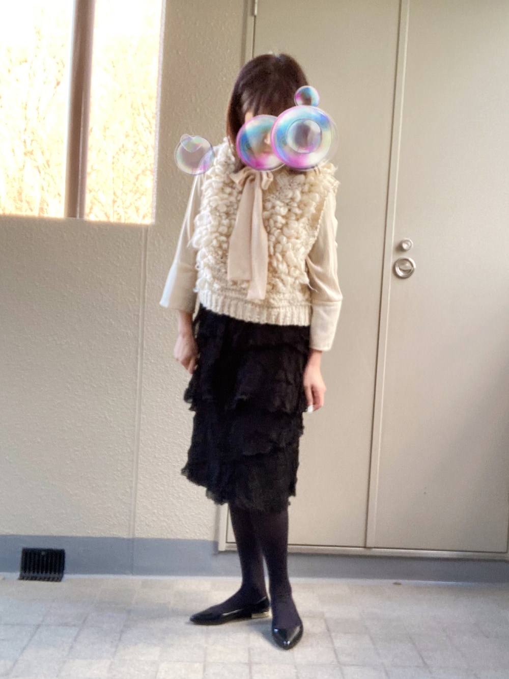 ベージュ系のニット/セーター、ベージュ系のシャツ/ブラウス、ブラック系のスカートを着用したレディースの冬コーディネートの2枚目の写真