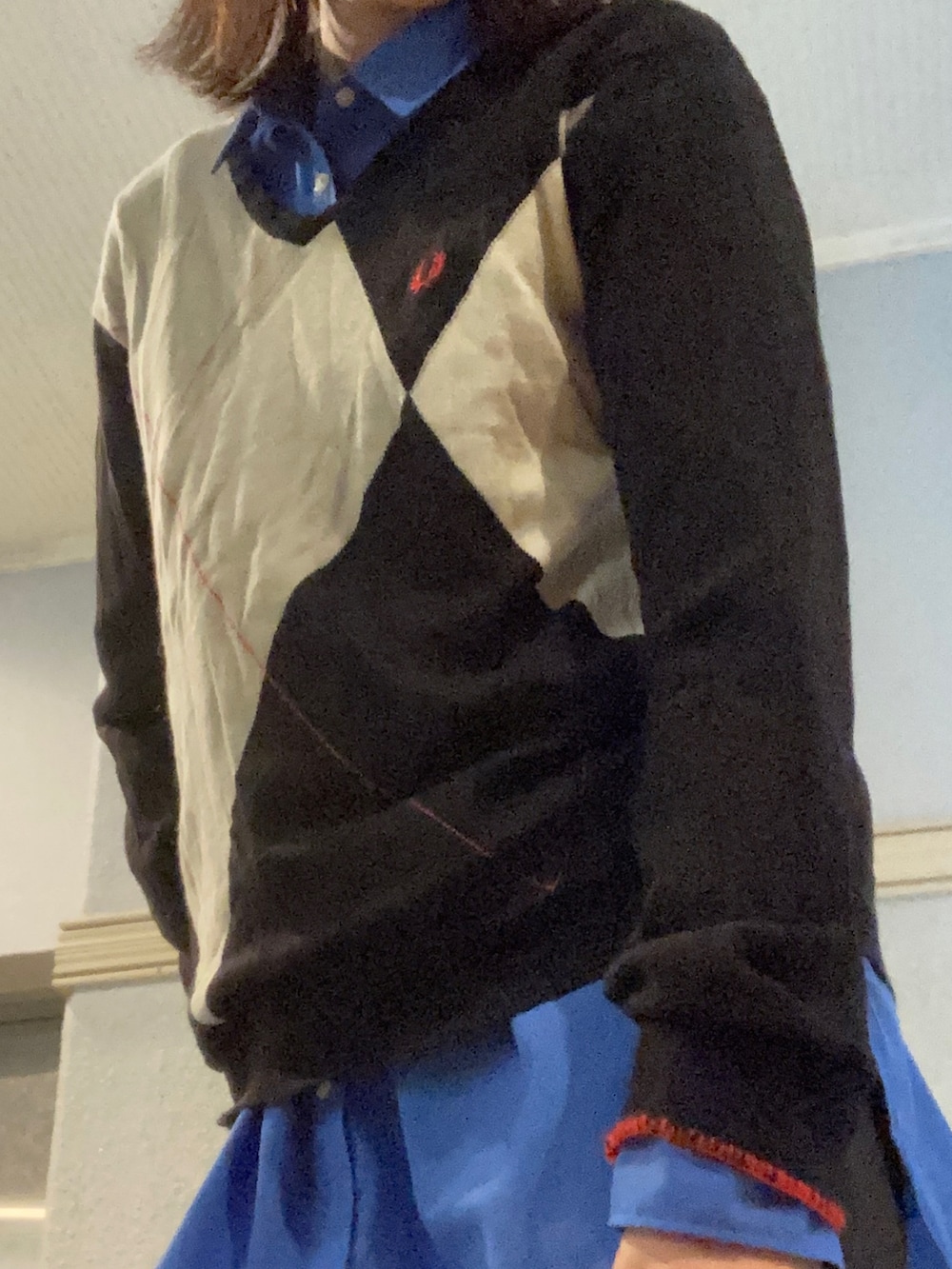 ブラック系のニット/セーター、ブルー系のシャツ/ブラウスを着用したレディースの秋コーディネートの2枚目の写真