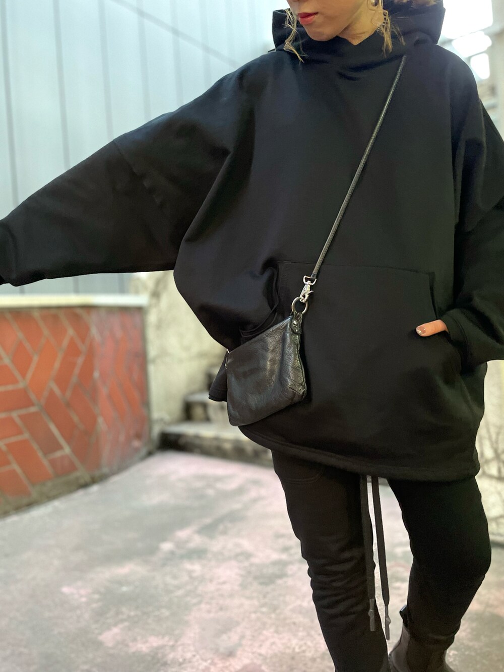 ブラック系のパンツ、ブラック系のショルダーバッグ、ブラック系のパーカーを着用したレディースの夏コーディネートの3枚目の写真