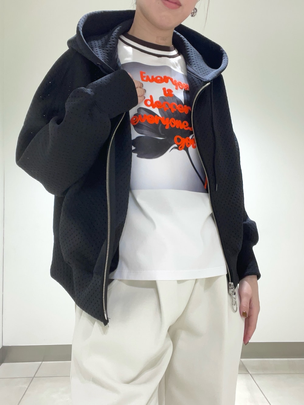 ブラック系のパーカーを着用したレディースの春コーディネートの2枚目の写真