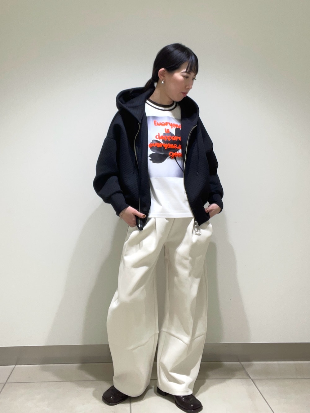 ブラック系のパーカーを着用したレディースの春コーディネートの3枚目の写真