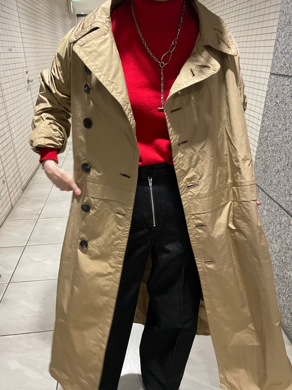 レッド系のニット/セーター、ブラック系のデニムパンツ、ブラック系のブーツを着用したレディースの冬コーディネートの2枚目の写真