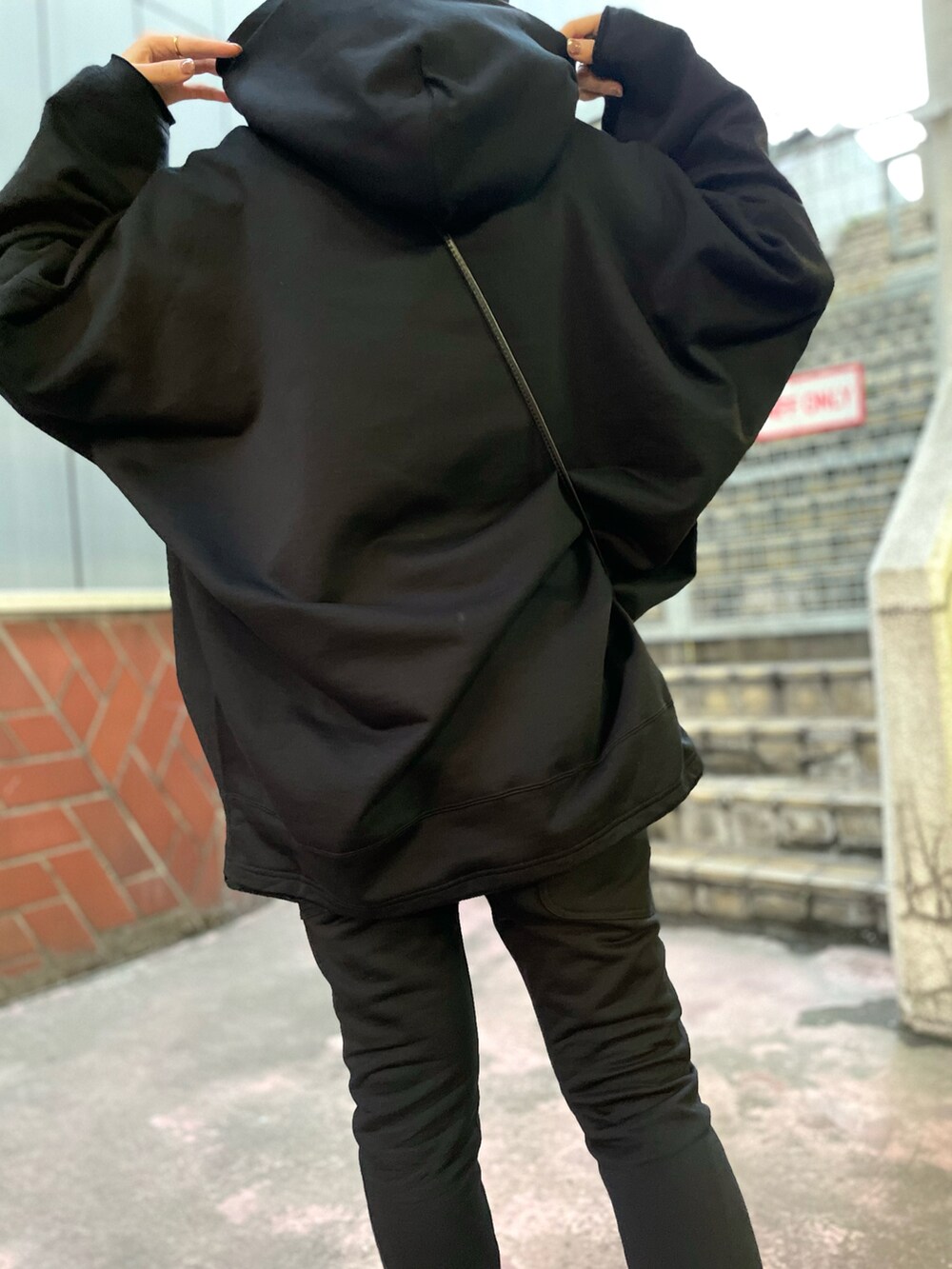 ブラック系のパンツ、ブラック系のショルダーバッグ、ブラック系のパーカーを着用したレディースの夏コーディネートの4枚目の写真