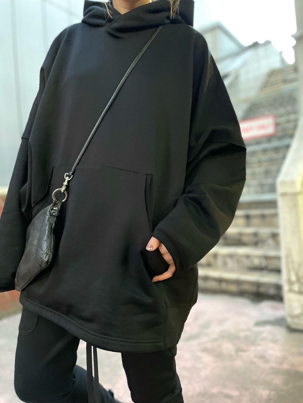 ブラック系のパンツ、ブラック系のショルダーバッグ、ブラック系のパーカーを着用したレディースの夏コーディネートの5枚目の写真