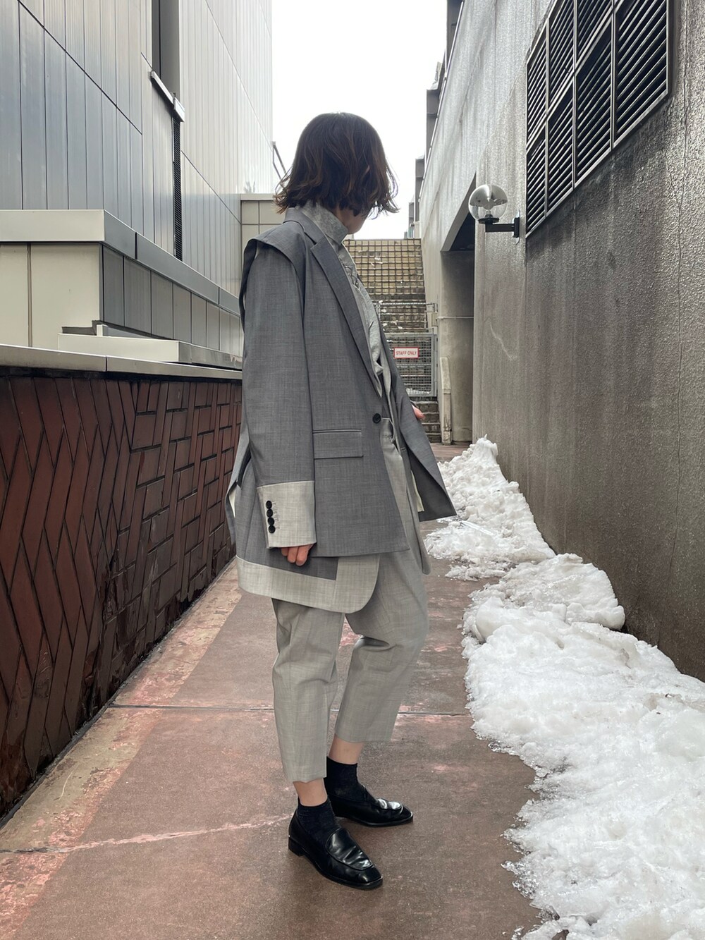 グレー系のニット/セーター、シルバー系のネックレスを着用したレディースの冬コーディネートの3枚目の写真