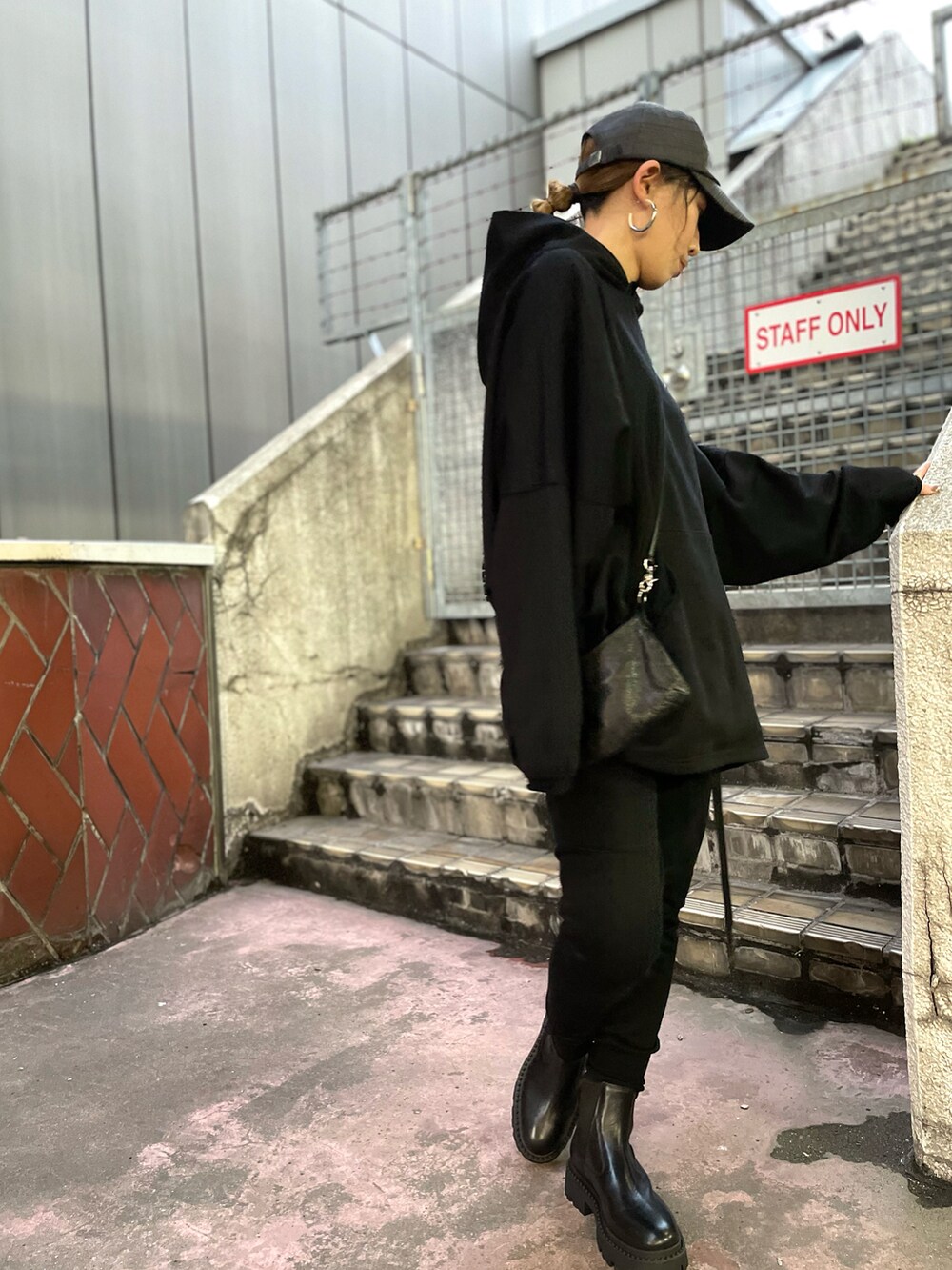 ブラック系のパンツ、ブラック系のショルダーバッグ、ブラック系のパーカーを着用したレディースの夏コーディネートの2枚目の写真