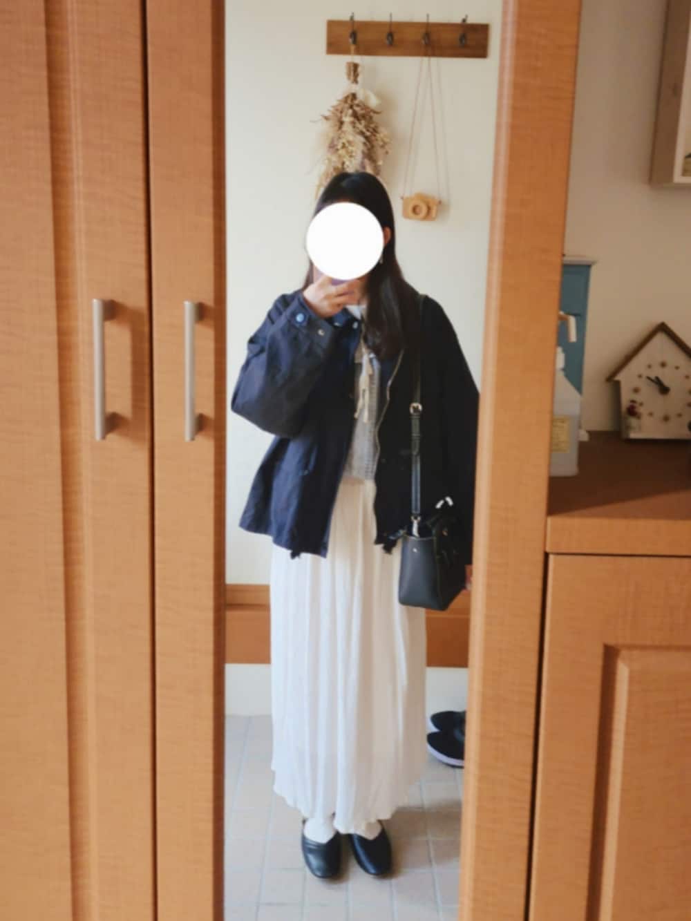 ブラック系のミリタリージャケット、ブルー系のニット/セーター、ホワイト系のシャツ/ブラウスを着用したレディースの冬コーディネートの2枚目の写真