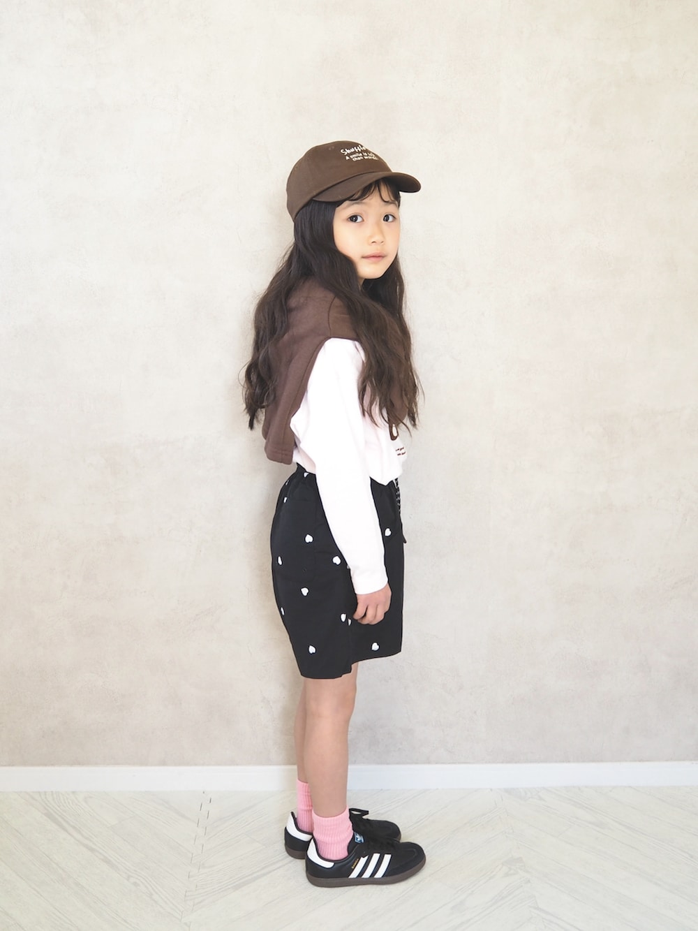 ブラウン系のカーディガン/ボレロ、ピンク系のTシャツ/カットソー、ブラック系のその他パンツを着用したキッズの春コーディネートの3枚目の写真