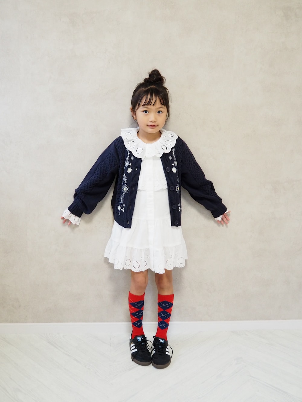 ホワイト系のワンピース、ブルー系のカーディガン/ボレロ、レッド系のソックス/靴下を着用したキッズの秋コーディネートの4枚目の写真