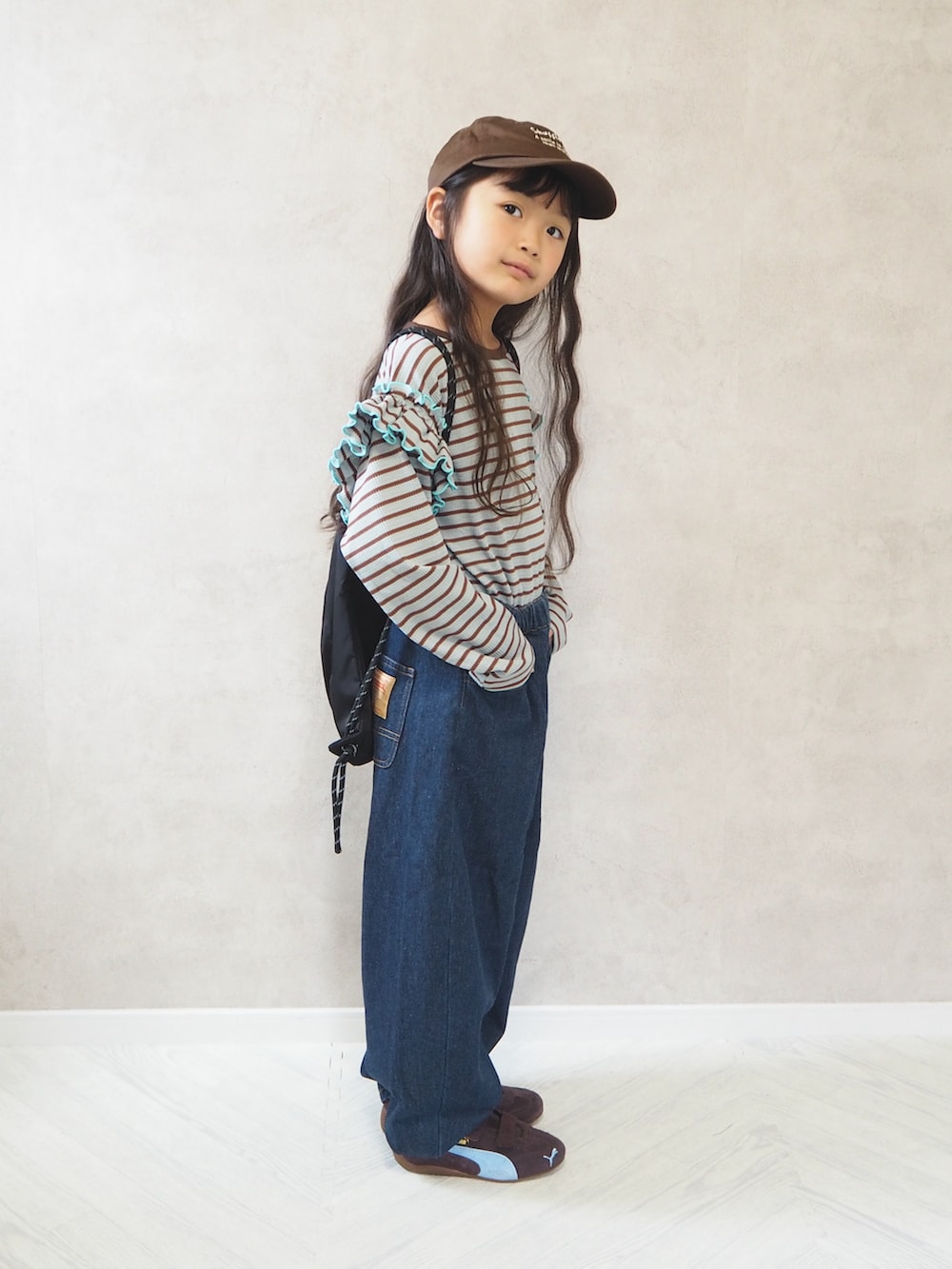 ブラック系のバックパック/リュック、グリーン系のTシャツ/カットソー、ブルー系のデニムパンツを着用したキッズの秋コーディネートの5枚目の写真