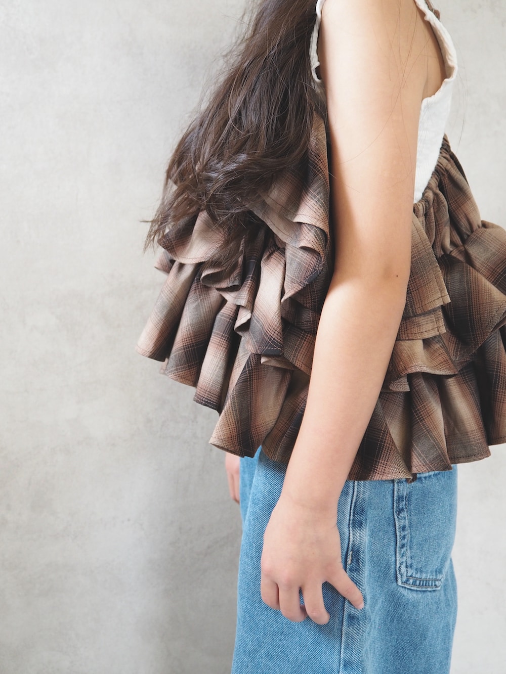 ブラウン系のキャミソール、ブルー系のパンツ、ブルー系のキャップを着用したキッズの夏コーディネートの4枚目の写真