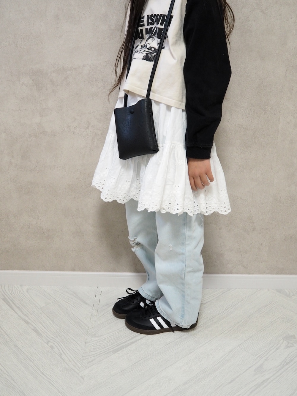 ブルー系のデニムパンツ、ブラック系のショルダーバッグ、ブルー系のキャップを着用したキッズの春コーディネートの3枚目の写真