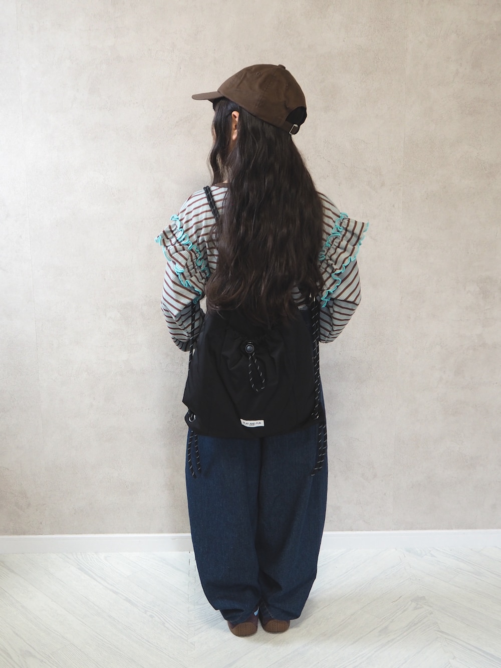 ブラック系のバックパック/リュック、グリーン系のTシャツ/カットソー、ブルー系のデニムパンツを着用したキッズの秋コーディネートの4枚目の写真