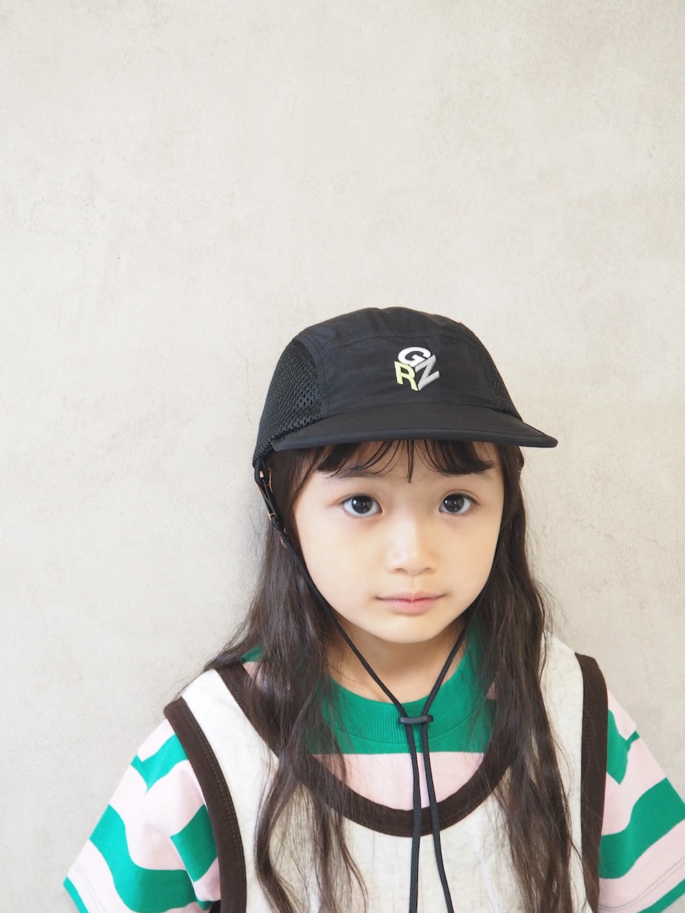 グリーン系のTシャツ/カットソー、ブラック系のスニーカー、ホワイト系のつなぎ/オールインワンを着用したキッズの夏コーディネートの4枚目の写真