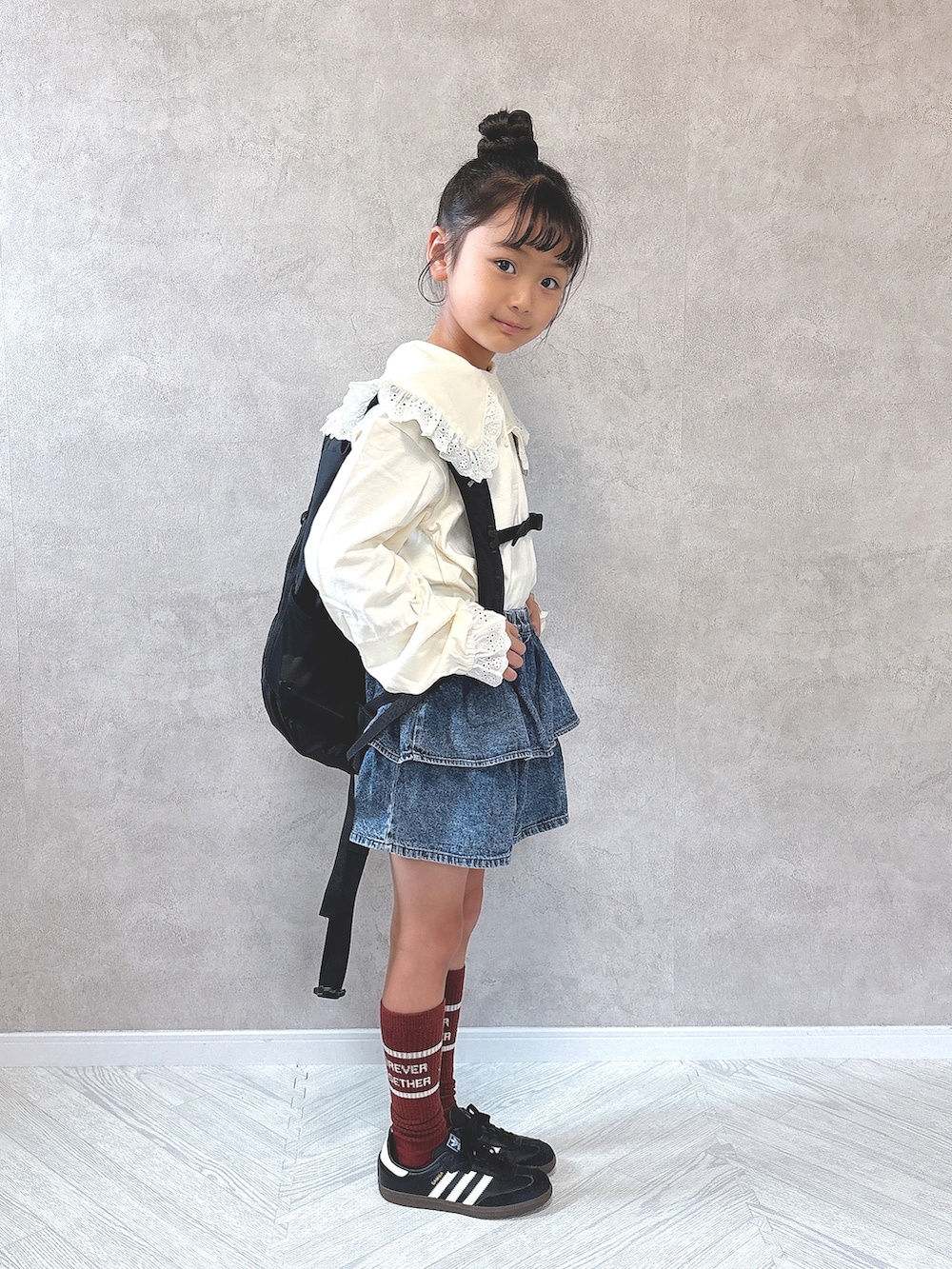 ブルー系のデニムパンツ、ブラック系のスニーカー、ホワイト系のTシャツ/カットソーを着用したキッズの秋コーディネートの2枚目の写真